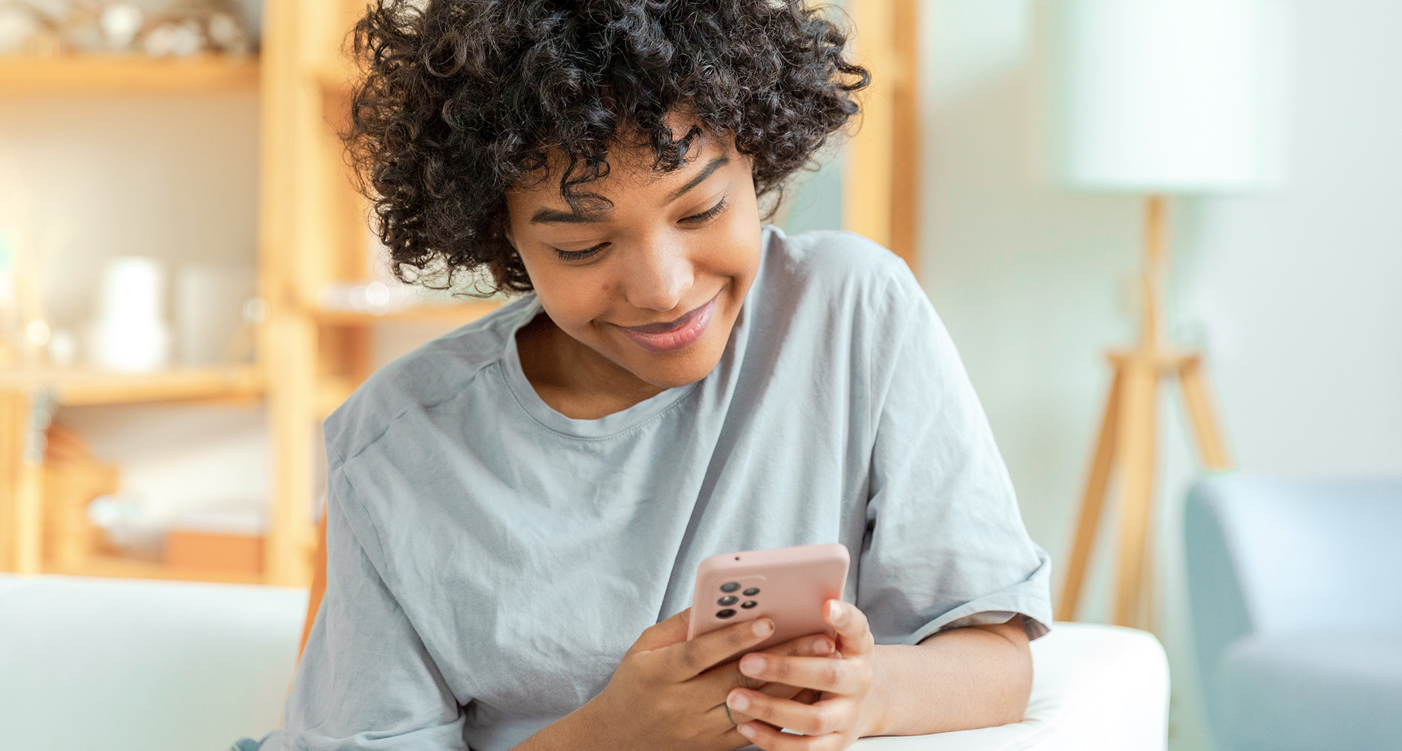 крупный план улыбающегося человека, смотрящего в мобильный телефон